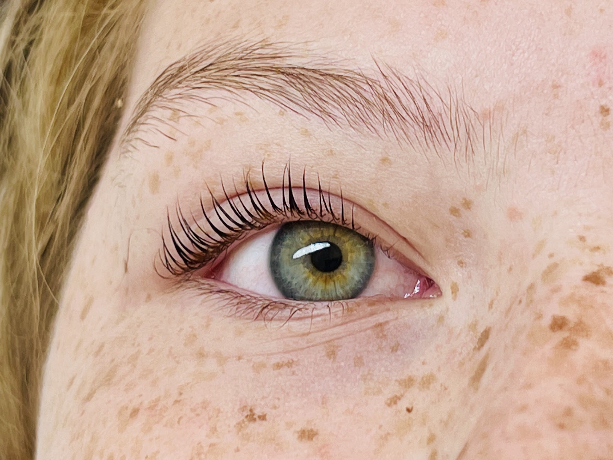 A freckled client’s eye after a Korean lash lift and tint